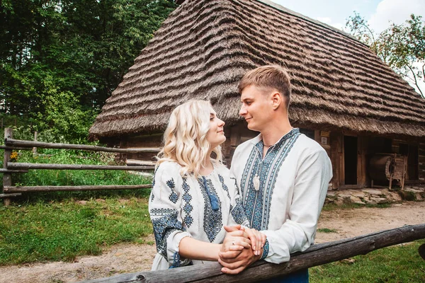 Couple de mariage incroyable tenant la main et étreignant sur un fond de maison en bois — Photo