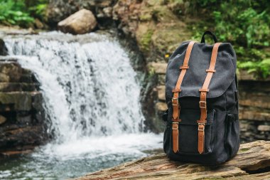Nehir ve şelale arka planda Hipster yürüyüşçü turist sırt çantası , gezgin tatil konsepti, seyahat macera dinlenmek.