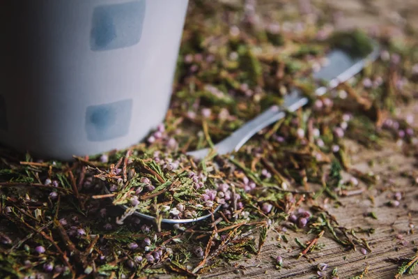 Taza y cuchara con té negro con flores sobre un fondo de madera. Desayuno, salud, terapia herbal, comida saludable. Concepto y composición . —  Fotos de Stock