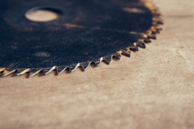 Tahta masanın arka planında yakın plan dairesel testere var. Ahşap ürünlerin üretimi için atölye çalışması. Katılımcılar kesme aracı. Bedava fotokopi alanı olan arkaplan. Üst görünüm