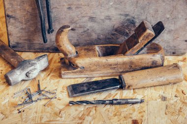 Ahşap tezgahtaki eski inşaat aletleri arka planda duruyordu. Marangoz masası. Ahşap