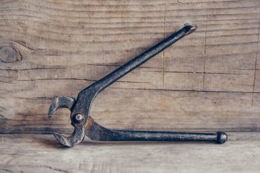 Ahşap arka planda paslı kıskaçlar. Bir şeyleri kavramak ve çekmek için bir araç
