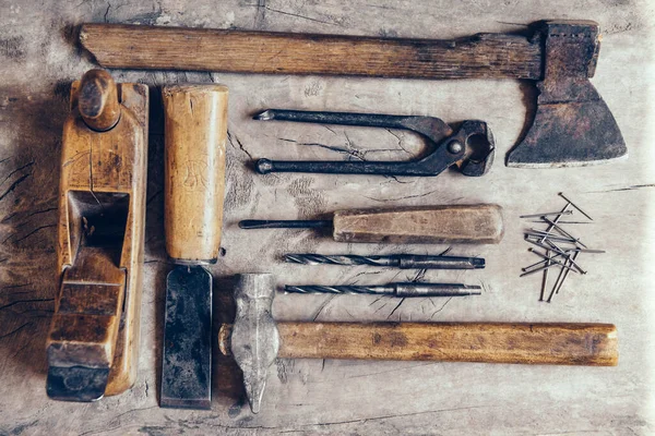 Old construction tools on a wooden workbench flat lay background. Carpenter table. Woodwork