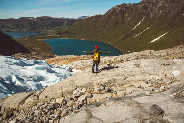 Hombre viajero con una mochila amarilla con un sombrero rojo de pie sobre una roca en el fondo de la montaña y el lago. Espacio para tu mensaje de texto o contenido promocional. Concepto de estilo de vida. Dispara. — Foto de Stock