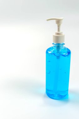 El yıkama için alkol jeli şişeleri. Alkol dezenfekte ediliyor. El yıkama alkolünün beyaz arka planda açık mavi bir rengi vardır..