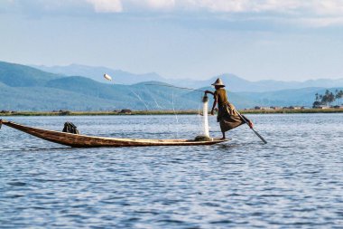 Inle Gölü'nde balıkçı kürek teknesi bacakla, Myanmar.