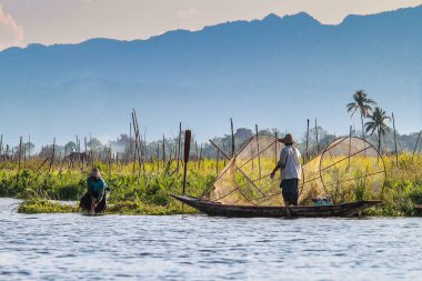 Inle Gölü'nde balıkçı kürek teknesi bacakla, Myanmar.