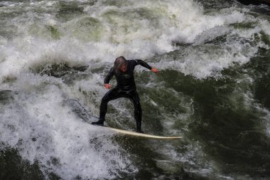 Münih, Almanya - 13 Ekim 2018: Eisbach adlı şehir nehrinde sörfçü