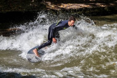 Münih, Almanya - 13 Ekim 2018: Eisbach adlı şehir nehrinde sörfçü