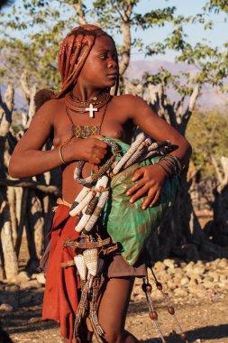 Opuwo, Namibya - Temmuz 08, 2019: Himba köyünde tipik kolye ve saç stiline sahip tanımlanamayan Himba kadını