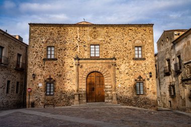 İspanya, Extremadura, Caceres 'deki Piskoposluk Sarayı. Santa Maria Meydanı 'nda, ana cephe, Rönesans tarzı, çift sıra küllerle süslenmiş yarım nokta kemerli dubası var.