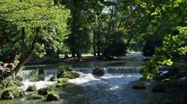 Almanya 'nın Münih kentindeki İngiliz Bahçesi' ndeki Eisbach nehrinde küçük bir şelale.