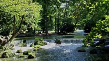 Almanya 'nın Münih kentindeki İngiliz Bahçesi' ndeki Eisbach nehrinde küçük bir şelale.
