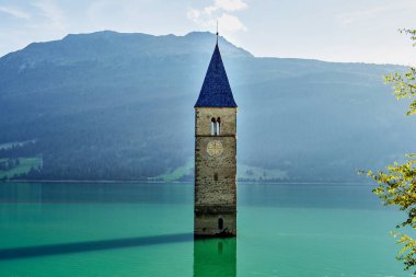 Güney Tyrol, İtalya 'daki Reschen Gölü' ndeki meşhur çan kulesi Lago di Resia. 2. Dünya Savaşı sırasında bir baraj inşa edildi ve köyü sular altına bıraktı, sadece kule hala görünür durumda..