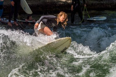 Münih, Almanya - 13 Temmuz 2019: Münih şehir nehrinde sörfçü, Eisbach adı verilen kentsel çevrede sörf yapan insanlarla ünlüdür.