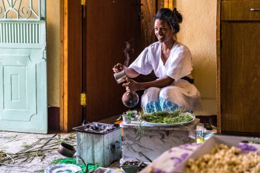 Axum, Etiyopya - 9 Şubat 2020: Geleneksel giysiler içinde genç bir kadın bir kahve seremonisi hazırlıyor. Bu tören Etiyopya kültürünün önemli bir parçasıdır..