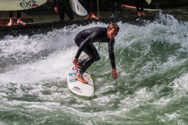 Münih, Almanya - 13 Temmuz 2019: Münih şehir nehrinde sörfçü, Eisbach adı verilen kentsel çevrede sörf yapan insanlarla ünlüdür.