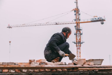 18 Aralık, 2014 Beijing. bir erkek Vinçler, takeing tuğla ile şehirde bir inşaat sitesinde