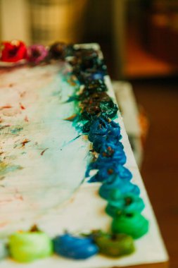 Yağlı boya bir paletle bir bulanıklık arka plan üzerinde renkli karışımı