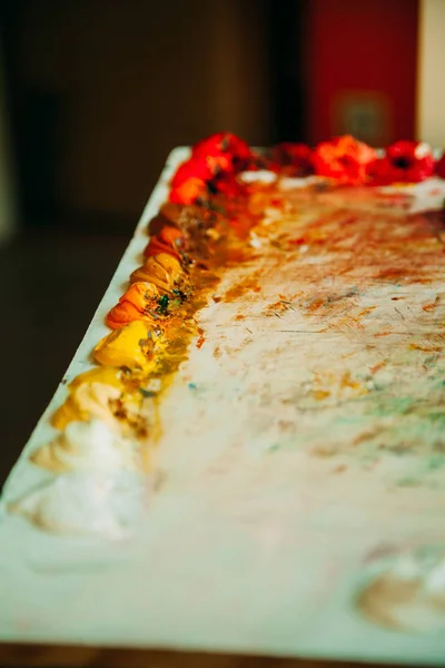 Yağlı boya bir paletle bir bulanıklık arka plan üzerinde renkli karışımı