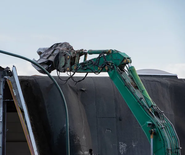 demolition excavator rips off a building