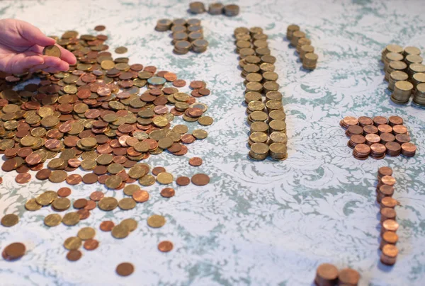 Small change Euro coins are counted by a woman