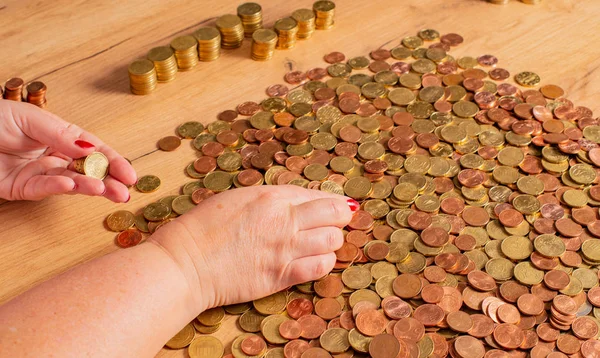 Small change Euro coins are counted by a woman