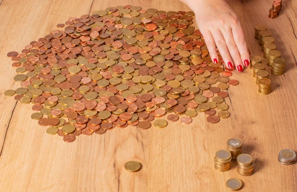 Small change Euro coins are counted by a woman