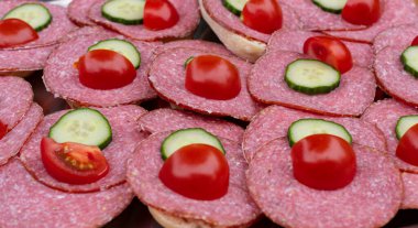 Dilimlenmiş sosis, salatalık ve domatesli rulo.