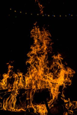 geceleri ahşap kütükler üzerinde bir yangın parlak turuncu diller. yanan odun. geceleri şenlik ateşi. Kamp ateşi. siyah arka plan üzerinde güzel alev. siyah arka plan üzerinde yangın. yanan odun . güzel yangın dokusu. kamp ateşinin dokusu