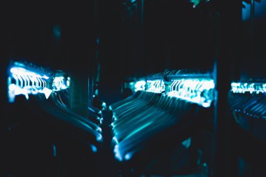 hangers hangers for clothes illuminated with neon tape hanging in a row