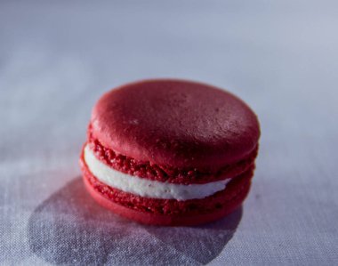 Lambaların ışığında beyaz kumaşlı arka planda kırmızı badem kurabiyesi. Güzel Bokeh.