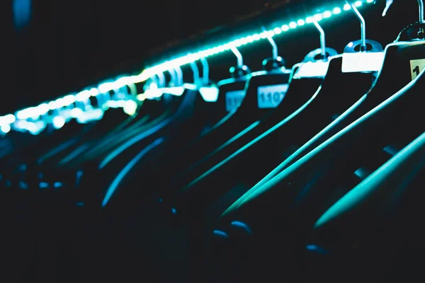 hangers hangers for clothes illuminated with neon tape hanging in a row