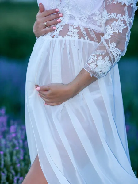 Schwangere im weißen Peignoir in einem Lavendelfeld — Stockfoto