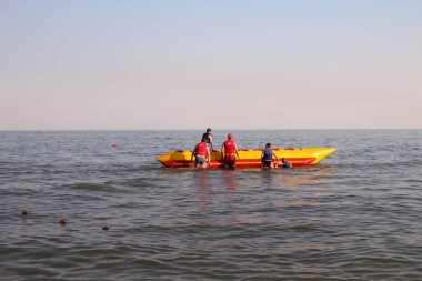 insanlar şişme bir muz üzerinde denize binmek