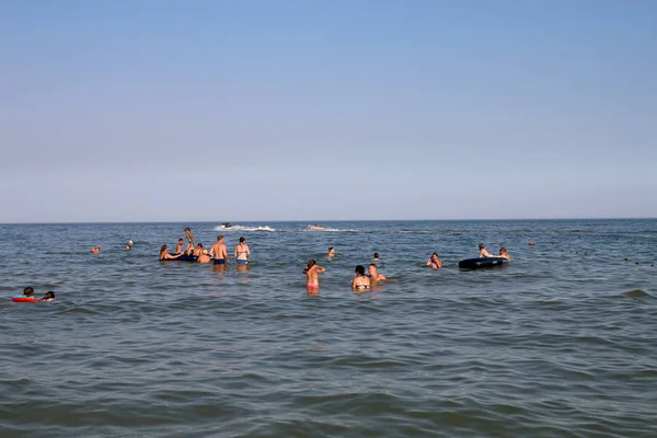 Adultos e crianças relaxam e nadam no mar — Fotografia de Stock