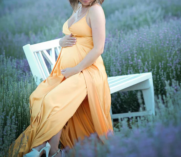 Ung flicka väntar på en baby promenader i lavendel — Stockfoto