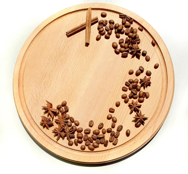 Canela e grãos de caféestão em uma tábua de madeira redonda e whit — Fotografia de Stock