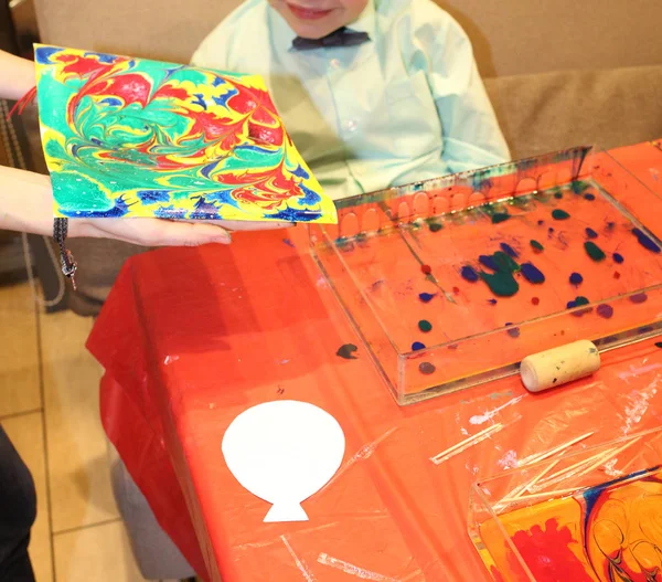 De jongen maakte een heldere schilderij met verven op het water — Stockfoto
