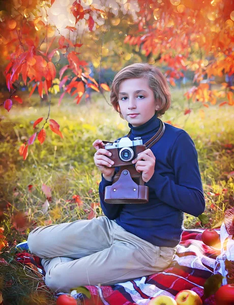 Jongen neemt foto op vintage camera in herfst Park — Stockfoto