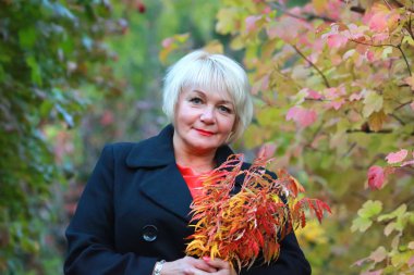 güzel bir sonbahar parkı orta yaşlı kadın doğanın tadını çıkarıyor