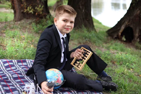 Ein Schüler in der Natur im schwarzen Anzug ruht nach der Schule — Stockfoto