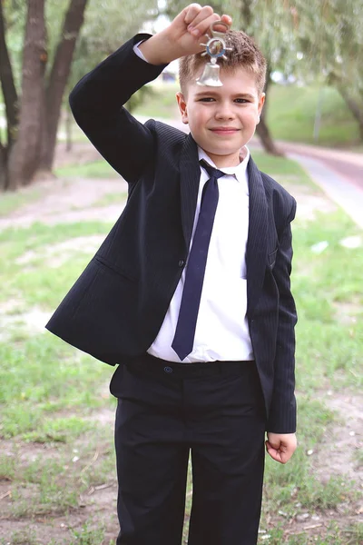 School jongen jongen ringen een kleine bel op 1 september — Stockfoto