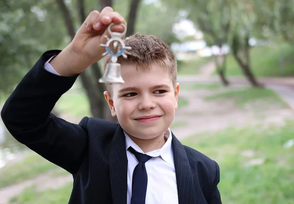 School jongen jongen ringen een kleine bel op 1 september — Stockfoto