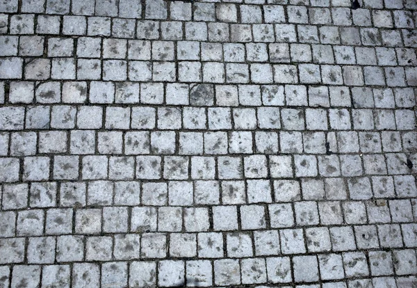 Gamla gå gångväg på gatan asfalterad med stenar — Stockfoto