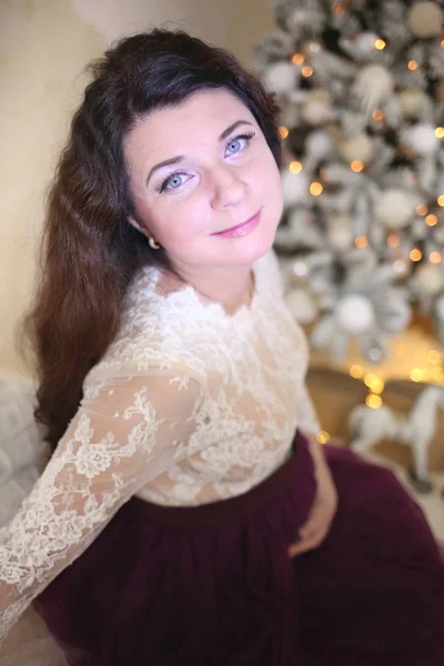 Беременная девушка в красивом интерьере студии празднует Рождество — стоковое фото