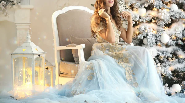 Ragazza di lusso in un bellissimo vestito seduto accanto a un albero di Natale — Foto Stock