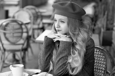 kırmızı bere genç ve ihale kız bir masada oturur ve bir sokak kafede kahve içiyor