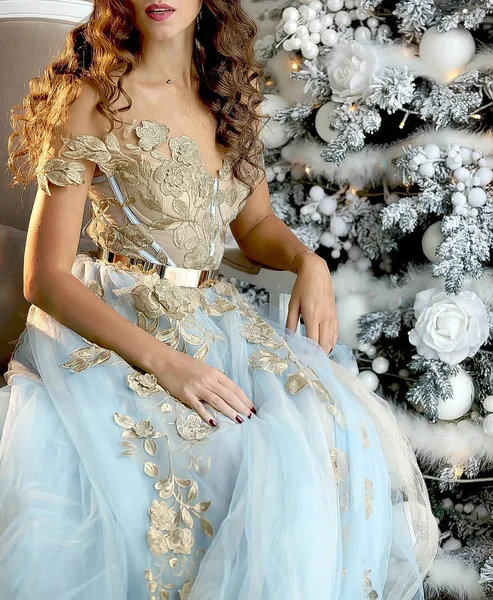 Luxuriöse Mädchen in einem schönen blauen Outfit in der Nähe eines Weihnachtsbaums — Stockfoto