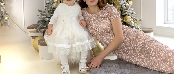Malé dítě v bílých šatech se svou matkou na Vánoce — Stock fotografie